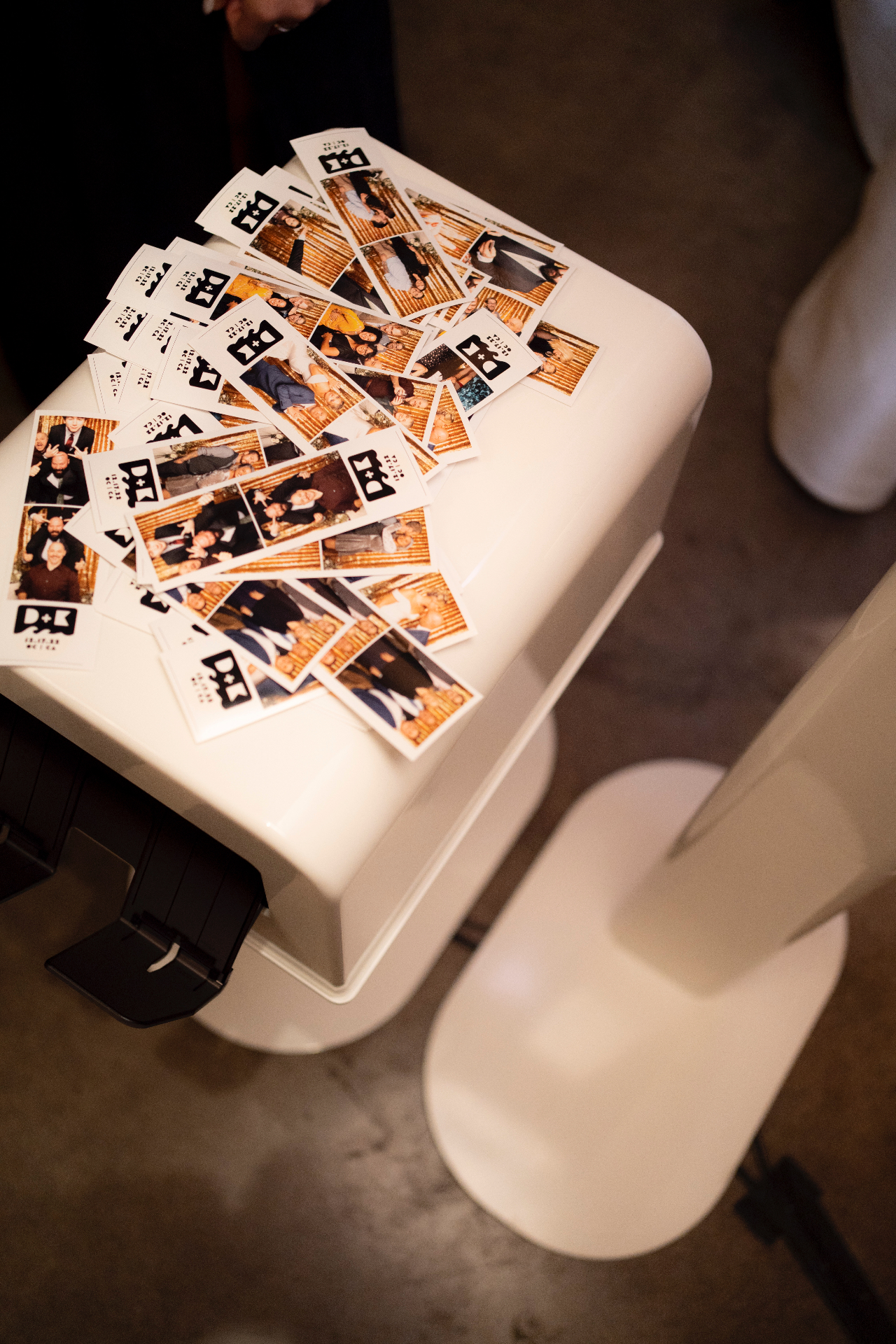 Freshly printed photo booth strips stacked on the printer tray